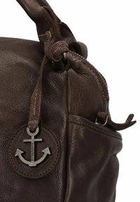 Bruine leren tas met een gestructureerd oppervlak, voorzien van een zilveren ankerbedel en contrasterende stiksels. Ritssluiting aan de bovenkant.