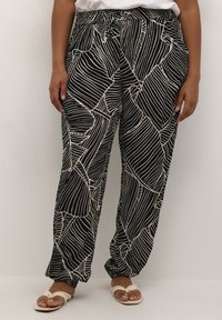 Schwarz-beige gemusterte Hose mit elastischem Bund und Kordelzug, versehen mit einem Blättermuster und schmal zulaufenden Bündchen an den Knöcheln.