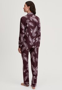 Langdurige, bordeauxrode pyjama set met een uil- en veerprint. Zachte stof; taillering met contrasterende biesaccenten.