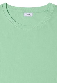 T-shirt en tissu tricoté côtelé vert menthe avec col rond et étiquette blanche cousue à l'intérieur du col indiquant "CECIL".