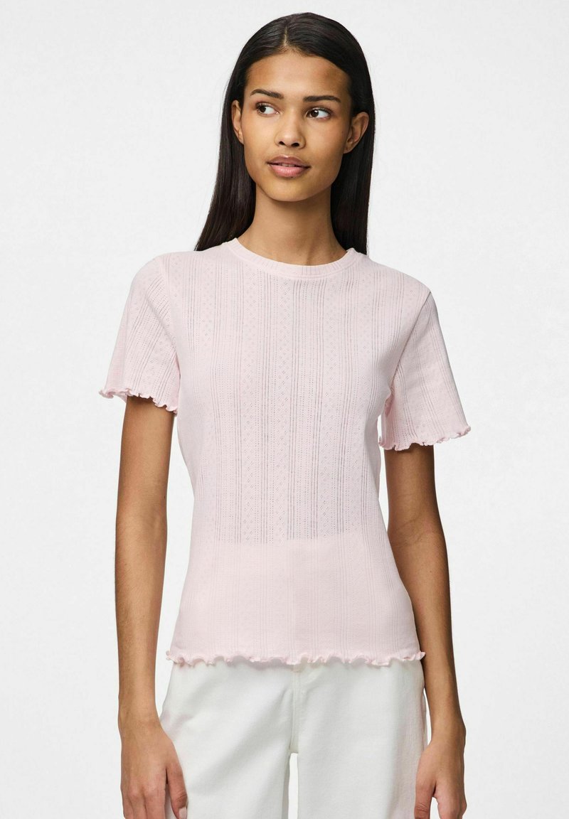 Jasnoróżowa bluzka z krótkim rękawem wykonana z teksturowanej tkaniny, z żebrowanym wzorem, falbaniastymi krawędziami i okrągłym dekoltem.