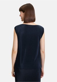 Marineblauw mouwloos topje met een losse pasvorm, voorzien van verticale ribbelstructuur en een brede halslijn, weergegeven vanuit de achterkant.