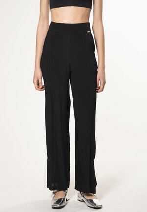 Zwarte wijdvallende broek van zachte, gestructureerde stof met een hoge tailleband; beschikt over subtiele zijzakken en minimale gouden hardwareaccenten.