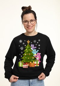 Sudadera negra con un diseño colorido de árbol de Navidad, decorado con adornos y rodeado de osos de dibujos animados y regalos envueltos.