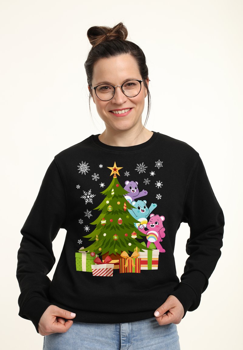 Sudadera negra con un diseño colorido de árbol de Navidad, decorado con adornos y rodeado de osos de dibujos animados y regalos envueltos.