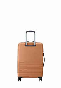 Valigia rigida con ruote a sfera di colore rame, con superficie rigata, manico retrattile e quattro ruote per una facile mobilità.