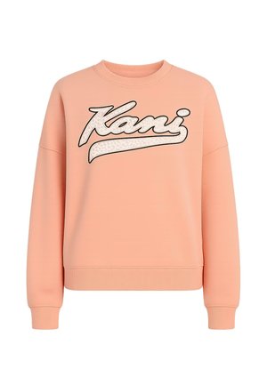 Persikatooniga sviiter, millel on ümar kaelus, langevad õlad ja ribidega mansetid. Omab julget "Kani" logo leopardimustriga.