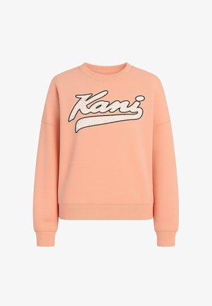 Persikatooniga sviiter, millel on ümar kaelus, langevad õlad ja ribidega mansetid. Omab julget "Kani" logo leopardimustriga.