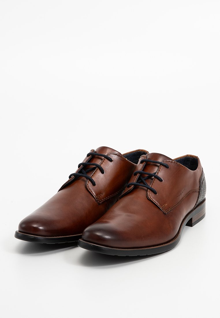 Braune Lederdressschuhe mit glatter Oberfläche, runder Zehenform, schwarzen Schnürsenkeln und strukturierten Akzenten an der Ferse. Klassisches Design mit feinen Details.