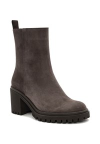 Brown suede ankle boot with a round toe, textured surface, and a chunky rubber heel featuring horizontal grooves for traction.