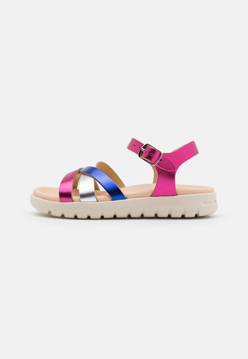 Sandales métalliques avec des brides roses, bleues et argentées. Elles présentent une semelle légère et texturée ainsi qu'une sangle de cheville réglable avec une boucle.
