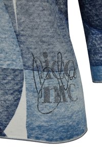 Blaue, abstrakte gemusterte Bekleidung aus weichem Stoff, mit langen Ärmeln und einem funkelnden schwarzen Textdesign auf der unteren Seite.