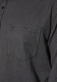 Schwarz-graues karierter Hemd mit Knöpfen, einer Brusttasche und abgerundetem Saum; zeichnet sich durch eine glatte Stoffoberfläche und Knöpfe aus.