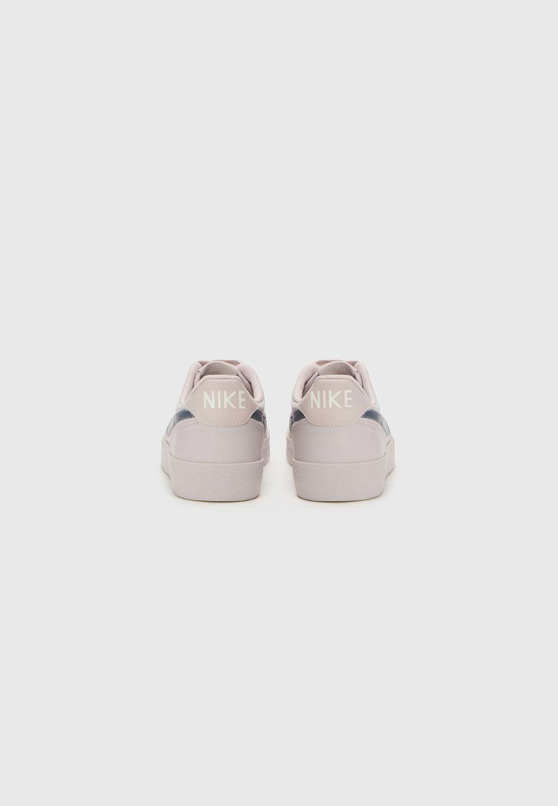 Sneakers Nike rosa con una superficie liscia, colletto imbottito e accenti grigi sui lati. Presentano un logo prominente sul tallone.