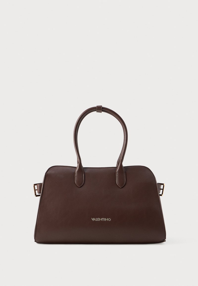 Brazdas ādas rokassoma ar strukturētu formu, divām noapaļotām rokturiem, zelta zīmogu un elegantu, minimālistisku dizainu.