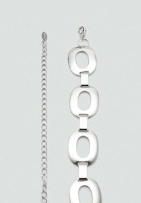 Silberne Metallkette Armband mit ovalen Gliedern und glatter Oberfläche, ergänzt durch einen Karabinerverschluss und eine verstellbare Kettenverlängerung.