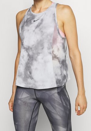 Top sportivo tie-dye grigio e bianco con scollatura rotonda, caratterizzato da un logo sottile e un design a strati. Indossato con leggings a motivo geometrico.