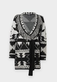 Svart og grå strikket cardigan med geometriske mønstre, frynsete dyp V-hals, lange ermer, og et svart belte i midjen.