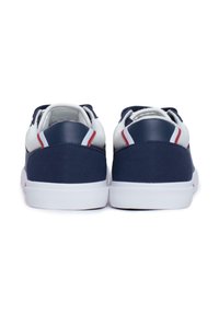 Zapatillas azul marino con acentos blancos, suelas de goma texturizadas y cuellos acolchados. Presentan un diseño combinado de cuero y tela.