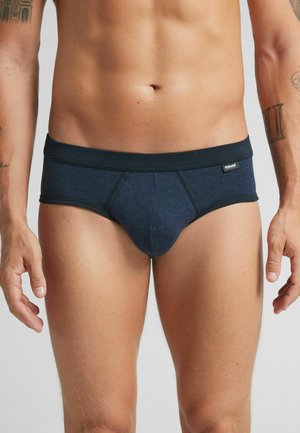 Marineblaue Slip aus strukturiertem Baumwollmix, mit einem breiten Bund, taillierter Passform und kontrastierenden Nähten für zusätzliche Details.