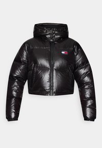 Chaqueta corta de plumas negra con exterior brillante, cierre de cremallera en la parte delantera y capucha. Presenta un logotipo en parche en el pecho y puños elásticos para un ajuste seguro.