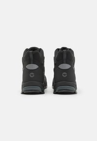 Botas de senderismo negras con un cuello acolchado, acentos grises, tejido texturizado y una suela de goma con patrón. Talón reforzado para mayor durabilidad.