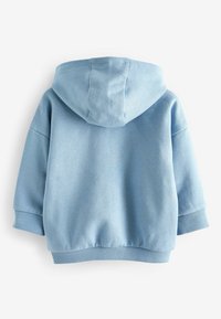 Sudadera azul claro hecha de tela suave, con una gran capucha, puños y dobladillo acanalados, y un corte relajado. Superficie texturizada con un leve brillo.