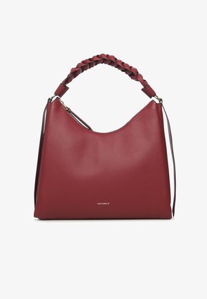 Rode leren handtas met een slordige vorm, gevlochten handvat en gouden beslag. Heeft een ritssluiting en het merknaam "Coccinelle" aan de voorkant.