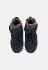 Baskets montantes bleu marine avec tige en daim, doublure grise moelleuse, sangle ajustable et lacets noirs contrastants avec semelle en caoutchouc.