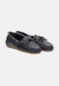 Mocasines de cuero negro con un acabado texturizado, puntera redondeada, costuras decorativas y detalles de cordones. Suela de goma para mayor durabilidad.