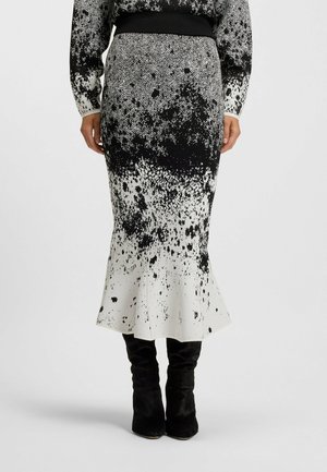 Zwart-witte midi-rok met een spetters patroon, voorzien van een gestructureerde herringbone tailleband en een uitlopende zoom.