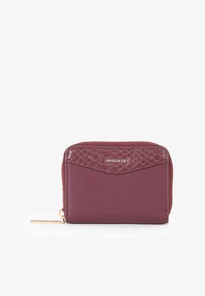 Portafoglio bordeaux con finitura liscia e dettaglio testurizzato. Presenta una chiusura con cerniera, un dettaglio con il logo e una forma compatta e rettangolare.