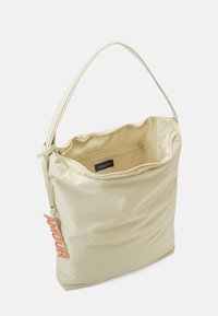 Beige ramenní taška s horním zipem, vnitřní zipovou kapsou a červeným klíčenkou "AMOUR" připevněnou na popruhu.