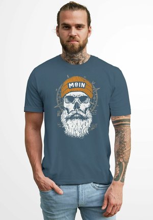 Dark blue t-shirt featuring a large skull graphic with a beard and orange knitted beanie, text "MOIN," and intricate line details.