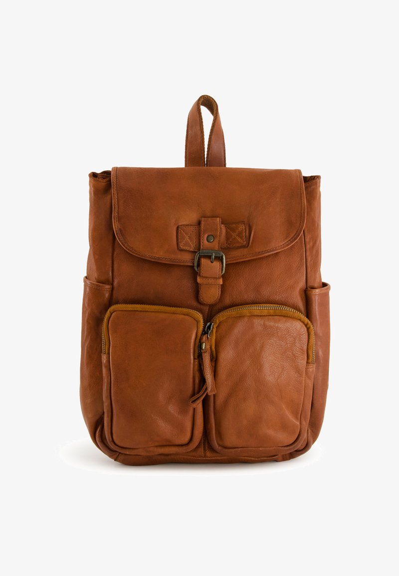 Brown leather backpack with a flap closure, two front zip pockets, and a top handle. Features a soft texture and a minimalist design.