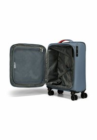 Valigia da cabina rigida di colore azzurro chiaro con maniglia superiore rossa, aperta per rivelare un interno grigio, tasca in rete e cinghie per un'imballaggio sicuro.