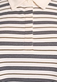 Le polo à rayures se distingue par un tissu léger et doux, orné de fines rayures horizontales en marine, marron et crème. Il comprend une patte de boutonnage.