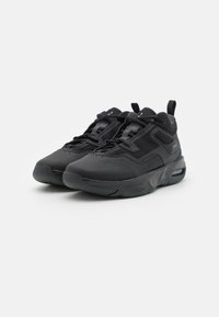 Czarne buty sportowe z połączeniem gładkich i teksturowanych materiałów, z miękką podeszwą, sznurówkami i uchwytem z tyłu.