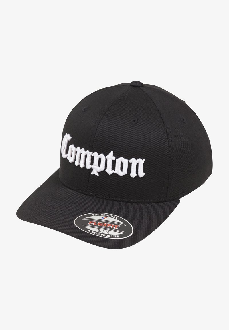 Black baseball cap with a curved brim, featuring white embroidered text "Compton" on the front. Includes a Flexfit logo sticker.