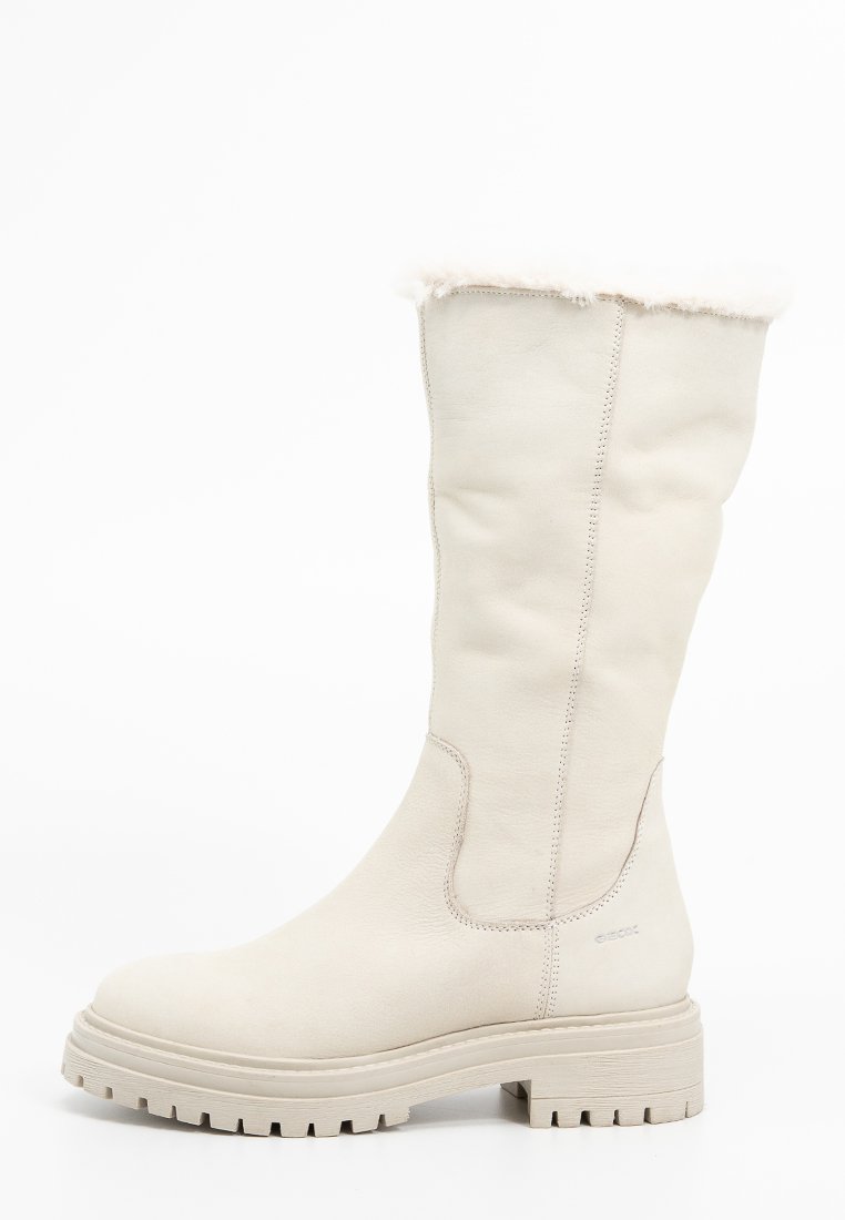 Botte blanche en cuir montée jusqu'au genou avec une bordure en fourrure douce en haut, tige texturée et semelle en caoutchouc blanche épaisse avec un motif à crans.