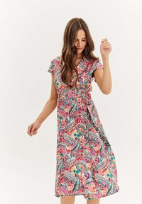 Midi šaty se vzorem, které mají krátké rukávy, zavinovací design a živé barvy jako růžová, zelená a modrá s květinovými a paisley motivy.