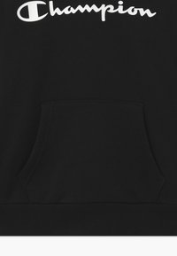 Felpa nera con cappuccio, dotata di tasca a marsupio, orlo a coste e un grande logo bianco "Champion" sul petto. Texture in tessuto morbido.