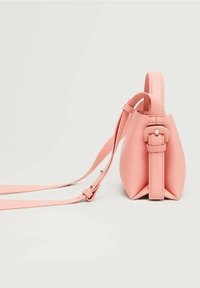 Sac à main en cuir rose avec une forme structurée, une sangle réglable et un détail de boucle. Texture lisse avec un design minimaliste.