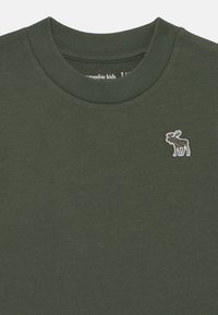 Mørkegrønn bomullssweatshirt med rund hals, med en liten brodert elg-logo i hvitt på brystet. Myk tekstur.