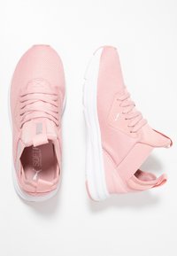 Un paio di scarpe da ginnastica Puma rosa con suole bianche, tomaia in mesh e lacci, mostrato in vista dall'alto e di lato su uno sfondo bianco.