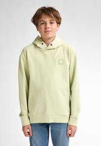 Felpa verde chiaro con tasca frontale, cappuccio con lacci e piccola toppa logo quadrata. Maniche lunghe con polsini e orlo a coste.