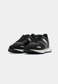 Czarne buty sportowe z szarymi akcentami i metalicznymi złotymi paskami. Posiadają teksturowaną cholewkę, okrągły czubek oraz wytłoczone logo z boku.