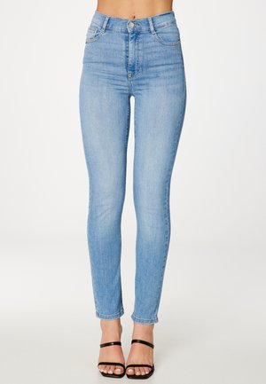 Hogewaisted, lichtblauwe denim skinny jeans met een gladde textuur, vier zakken en een knopenfly, gecombineerd met zwarte bandjesandalen.