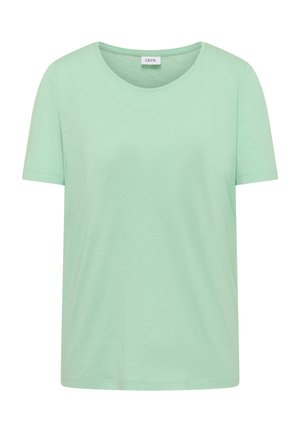 Miętowa bawełniana koszulka z krótkim rękawem, okrągłym dekoltem i metką "CECIL" wewnątrz kołnierza, przedstawiona z przodu na białym tle.