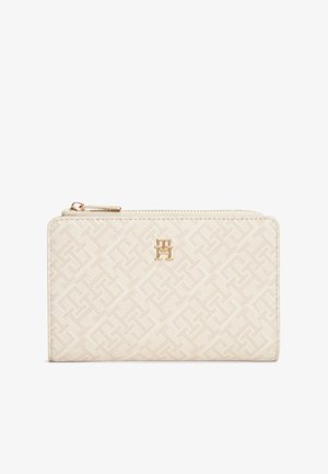 Πορτοφόλι σε κρεμ απόχρωση με υφή γεωμετρικό σχέδιο και χρυσό λογότυπο. Διαθέτει κλείσιμο με φερμουάρ και κομψό ορθογώνιο σχήμα.